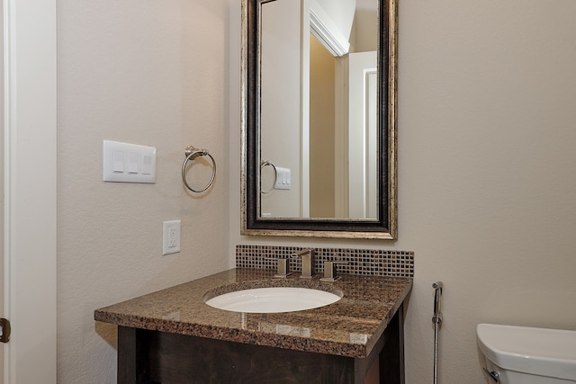 bathroom featuring decorative backsplash, vanity, and toilet