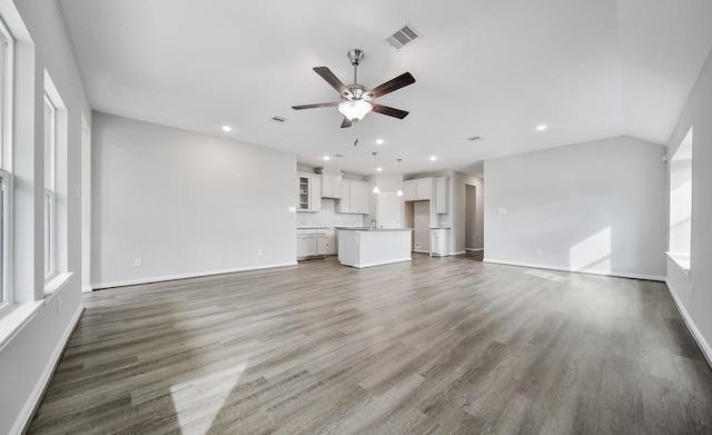 unfurnished living room with ceiling fan, dark hardwood / wood-style flooring, and vaulted ceiling