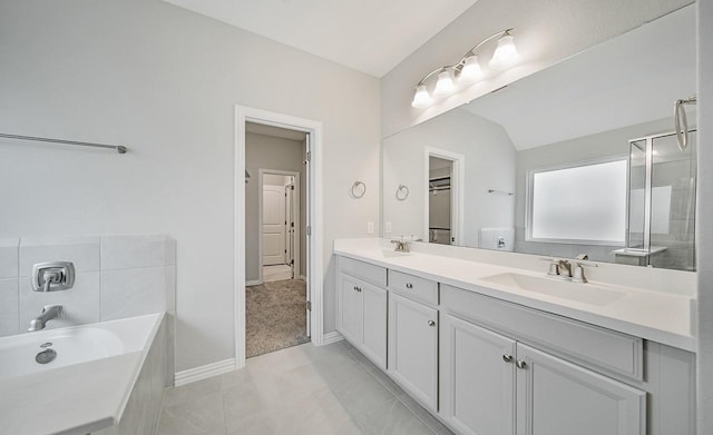 bathroom with tile patterned floors, vanity, a tub to relax in, and vaulted ceiling