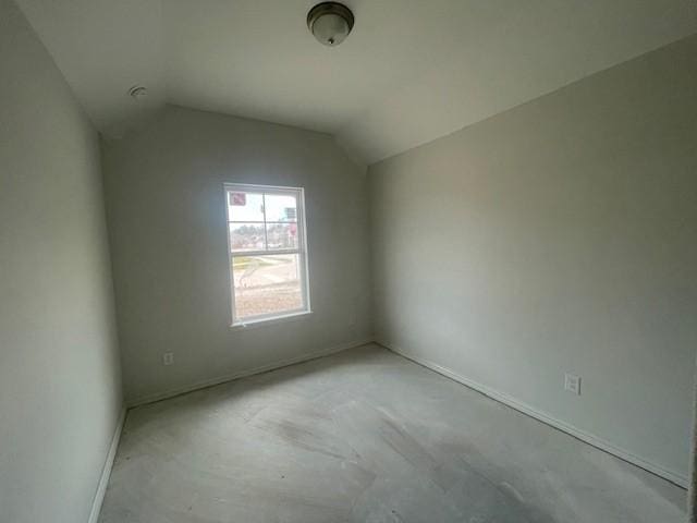 empty room featuring lofted ceiling