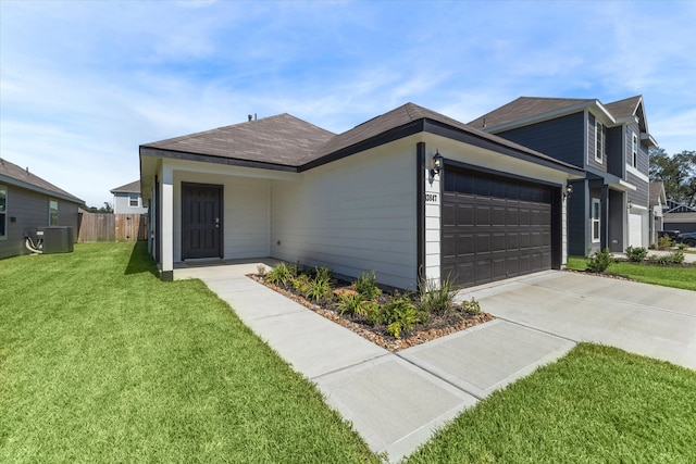 ranch-style house with a garage, a front lawn, and central air condition unit