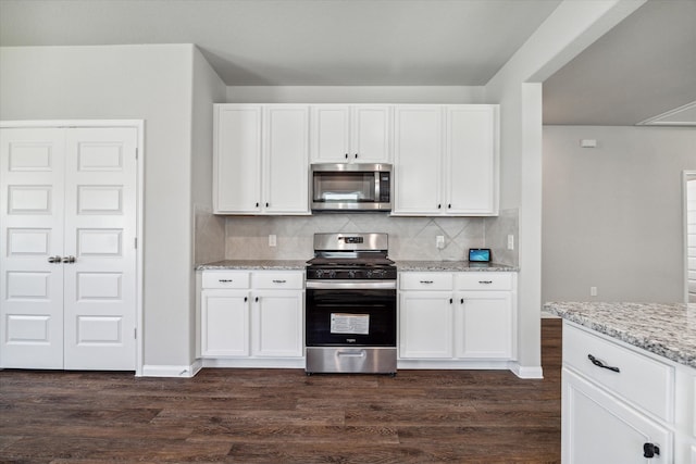 kitchen featuring white cabinetry, dark wood-type flooring, stainless steel appliances, and light stone counters