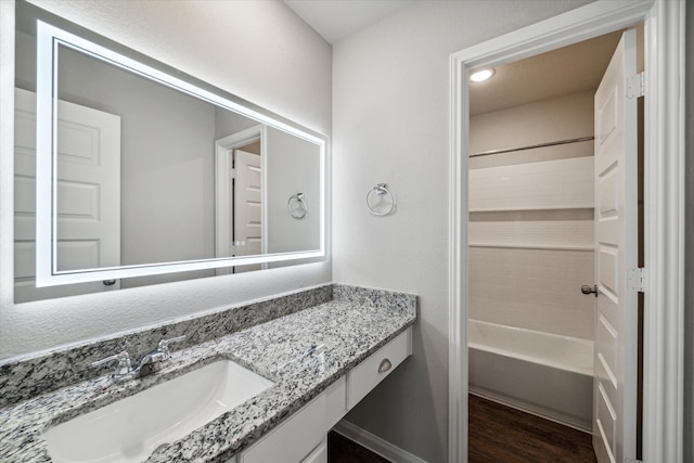 bathroom with bathing tub / shower combination, hardwood / wood-style floors, and vanity