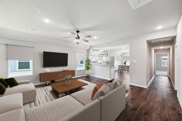 living room with dark hardwood / wood-style floors, ceiling fan, and a healthy amount of sunlight