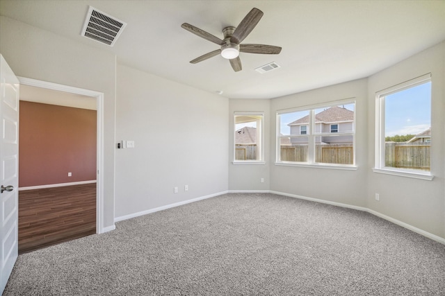 carpeted spare room featuring ceiling fan