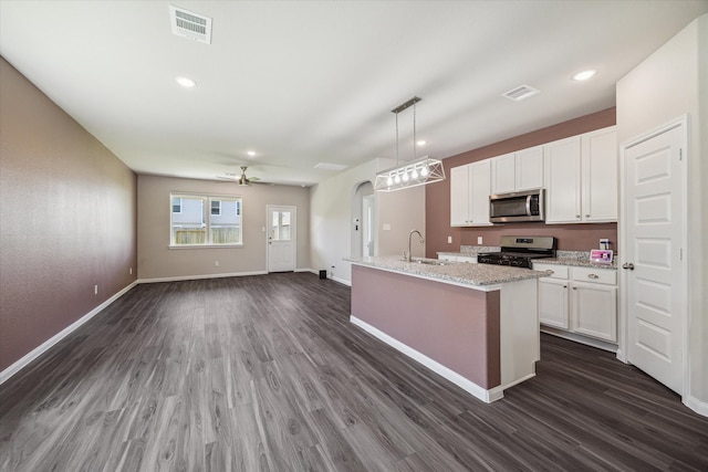 kitchen with stainless steel appliances, dark hardwood / wood-style flooring, decorative light fixtures, a center island with sink, and white cabinets