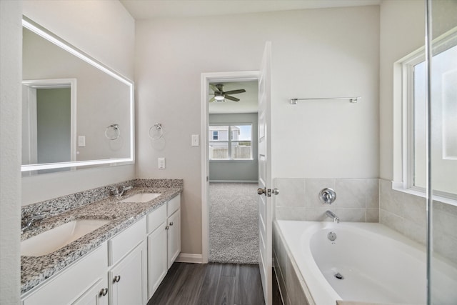 bathroom with a tub, ceiling fan, vanity, and hardwood / wood-style flooring