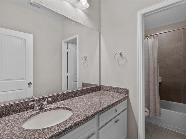 full bathroom featuring toilet, tile patterned floors, vanity, and shower / tub combo