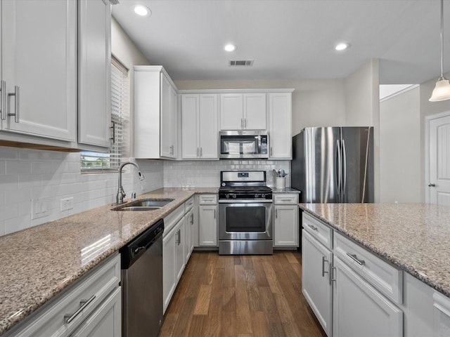 kitchen featuring decorative light fixtures, white cabinets, and appliances with stainless steel finishes