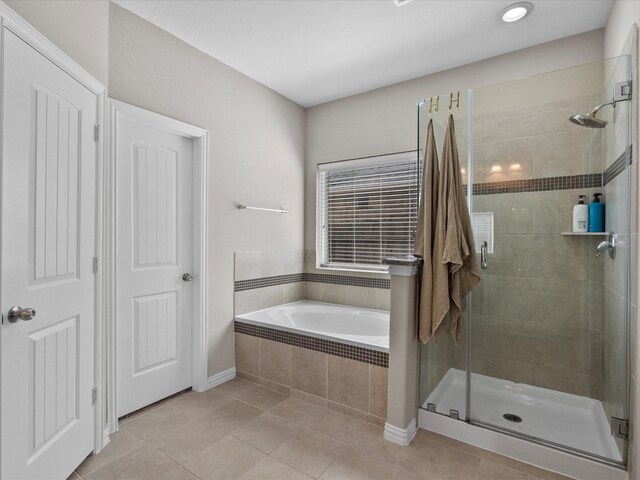 bathroom with tile patterned flooring and shower with separate bathtub