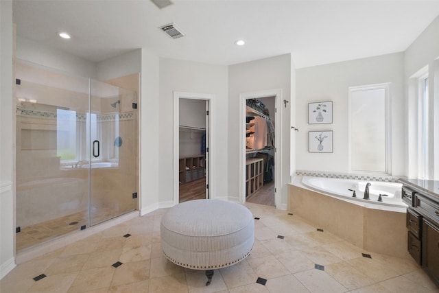 bathroom with tile patterned floors, independent shower and bath, and vanity