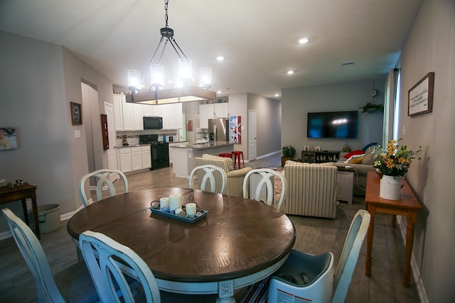 dining space with a chandelier, dark wood-type flooring, and sink