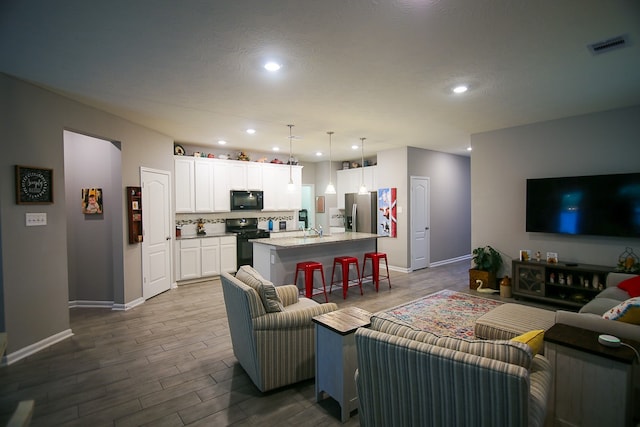 living room with hardwood / wood-style floors and sink