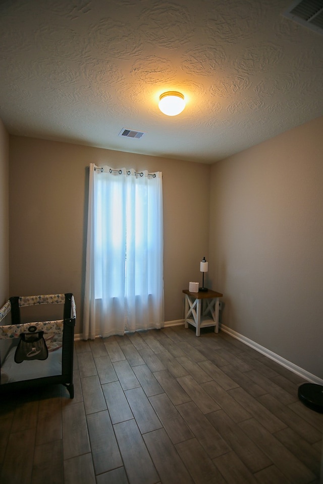 sitting room featuring a textured ceiling and dark wood-type flooring