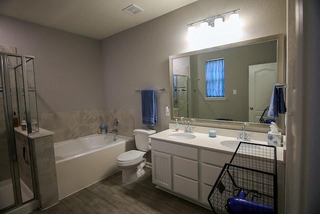 full bathroom featuring vanity, a textured ceiling, wood-type flooring, shower with separate bathtub, and toilet