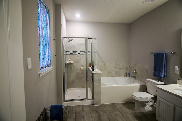 full bathroom with plus walk in shower, hardwood / wood-style floors, vanity, and toilet