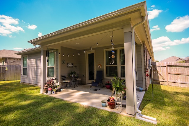 rear view of house featuring a patio and a yard