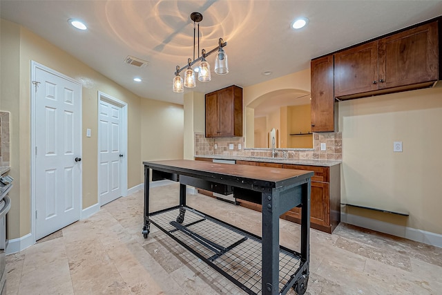 kitchen featuring decorative backsplash, sink, and pendant lighting