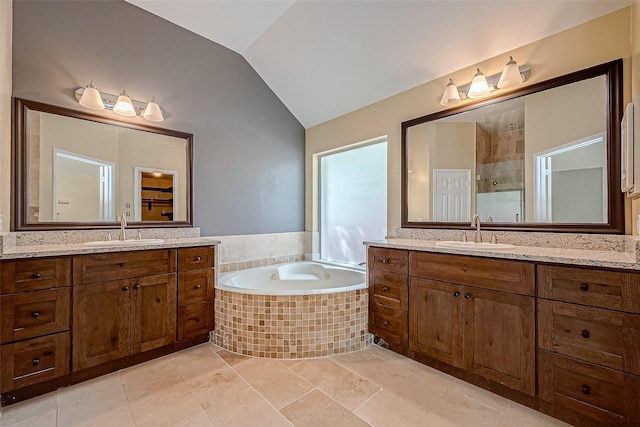 bathroom featuring plus walk in shower, vaulted ceiling, tile patterned floors, and vanity