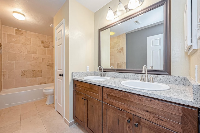 full bathroom featuring vanity, toilet, tiled shower / bath, and tile patterned flooring