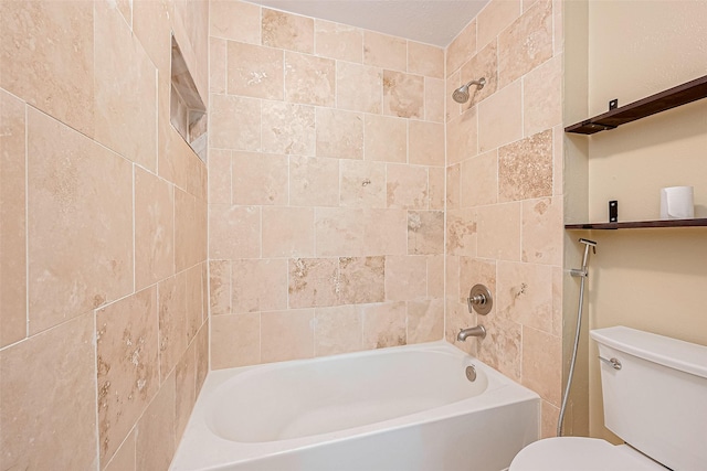 bathroom with tiled shower / bath combo and toilet