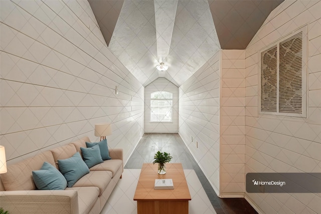 unfurnished living room with vaulted ceiling and tile walls