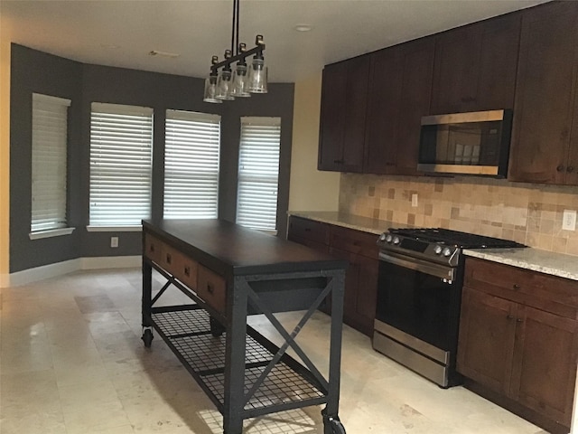 kitchen with stove, pendant lighting, decorative backsplash, and dark brown cabinetry