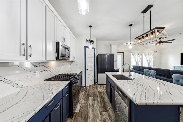 kitchen featuring pendant lighting, sink, white cabinets, and stainless steel appliances