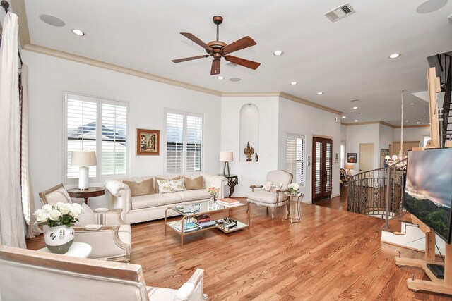 living room featuring crown molding, light wood-type flooring, and ceiling fan