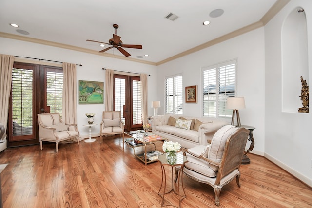 living room with light hardwood / wood-style flooring, ornamental molding, plenty of natural light, and ceiling fan