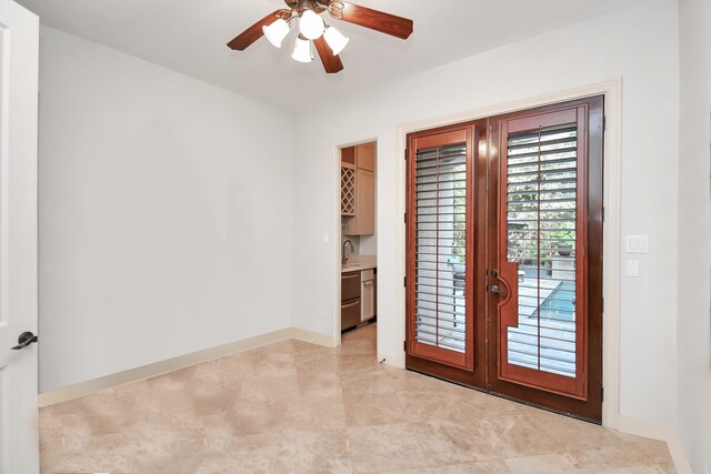 doorway with ceiling fan, sink, and light tile patterned floors