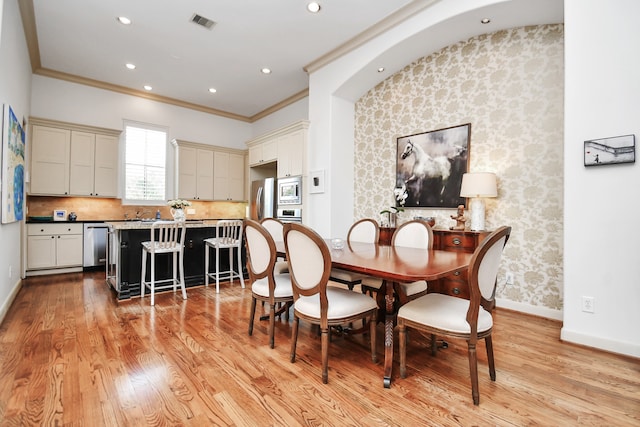 dining space featuring light hardwood / wood-style floors and ornamental molding