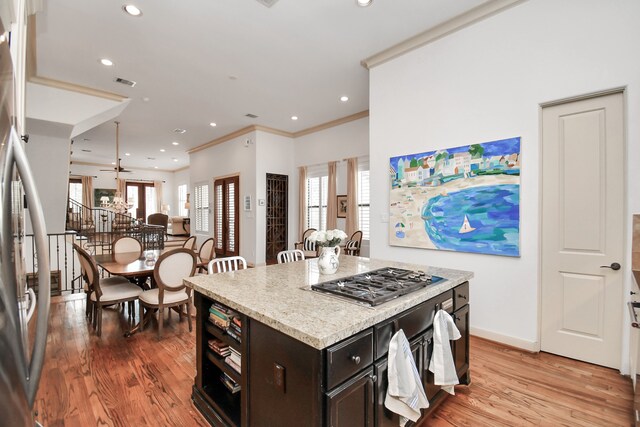 kitchen with ceiling fan, appliances with stainless steel finishes, a center island, and light wood-type flooring