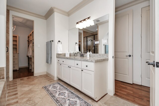 bathroom with a shower with door, vanity, ornamental molding, and hardwood / wood-style flooring