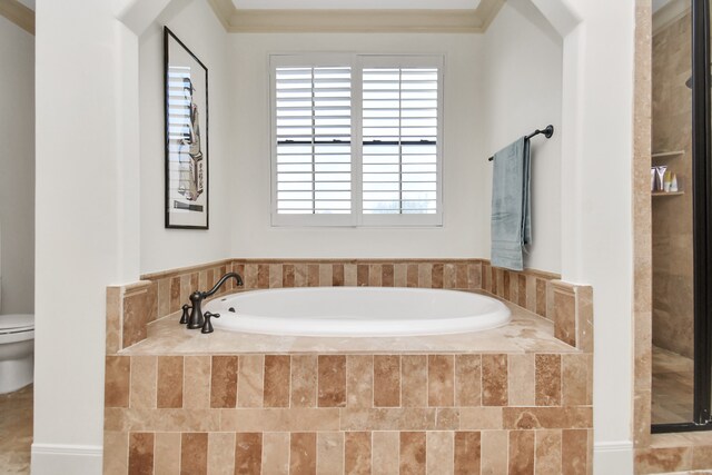 bathroom featuring crown molding, a relaxing tiled tub, and toilet