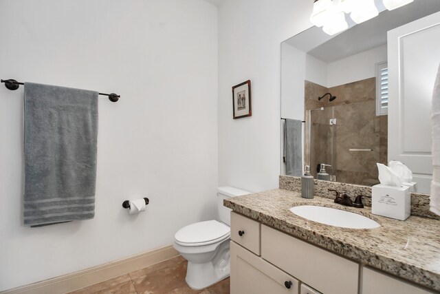 bathroom featuring vanity, a tile shower, toilet, and tile patterned floors