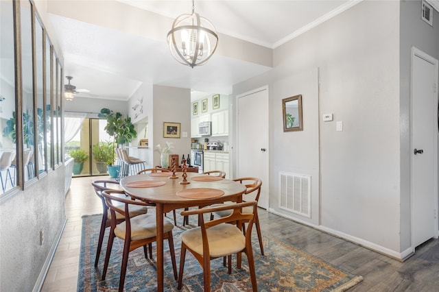 dining area with ceiling fan with notable chandelier, ornamental molding, and dark hardwood / wood-style floors