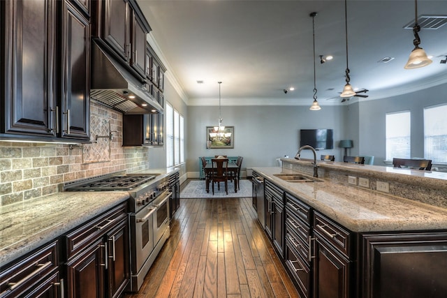 kitchen with sink, pendant lighting, a center island with sink, double oven range, and dark hardwood / wood-style floors