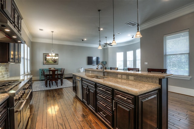 kitchen with dark brown cabinets, sink, stainless steel appliances, and decorative light fixtures