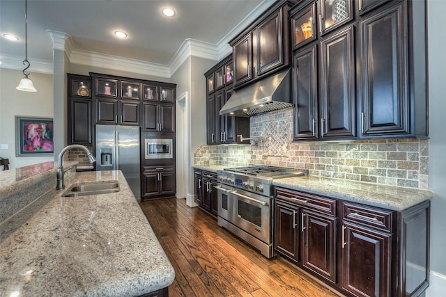 kitchen featuring dark hardwood / wood-style flooring, tasteful backsplash, stainless steel appliances, sink, and pendant lighting