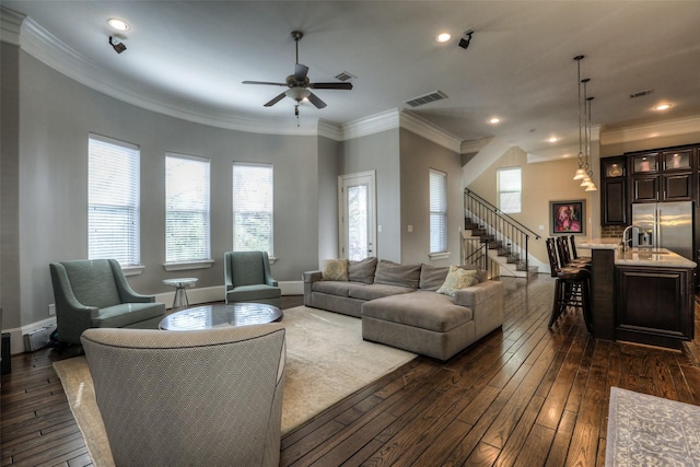 living room featuring ornamental molding, ceiling fan, and dark wood-type flooring