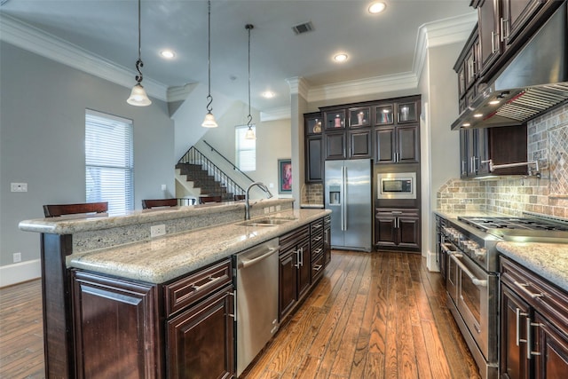 kitchen featuring sink, hanging light fixtures, dark hardwood / wood-style flooring, a breakfast bar area, and appliances with stainless steel finishes