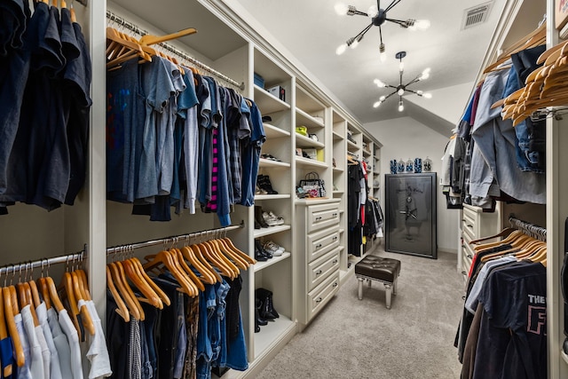 walk in closet featuring light carpet, lofted ceiling, and a notable chandelier