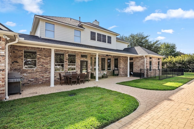 rear view of property featuring a lawn and a patio area