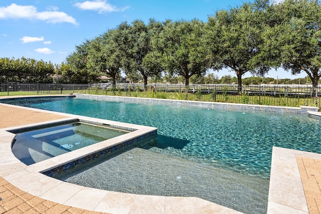 view of swimming pool with an in ground hot tub