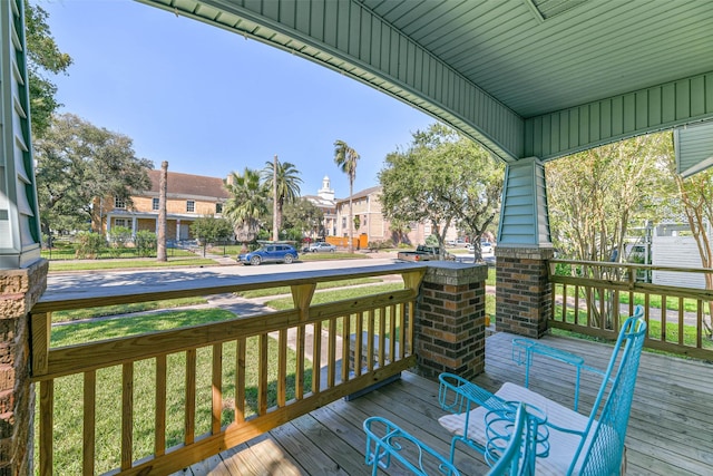 wooden deck with a residential view and covered porch