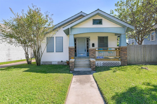 bungalow-style home featuring a porch, a front lawn, and fence