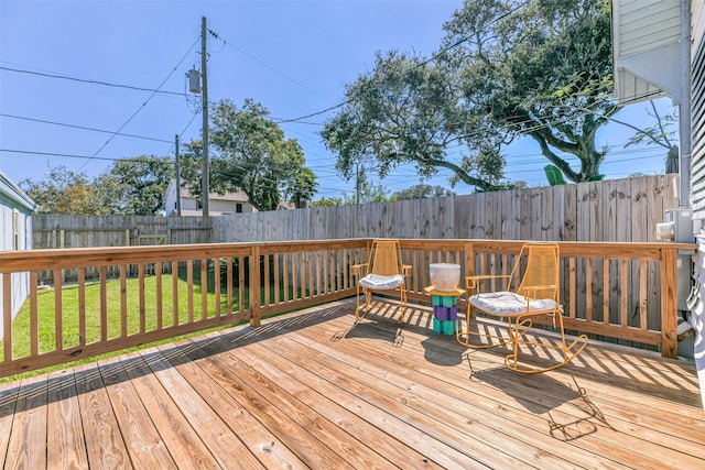 wooden deck featuring a fenced backyard and a yard