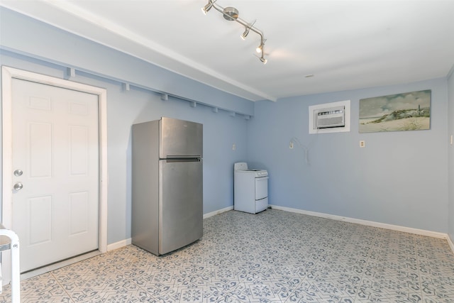 basement featuring stainless steel refrigerator, a wall mounted AC, and washer / dryer