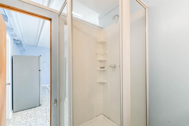 bathroom with a shower stall and tile patterned floors